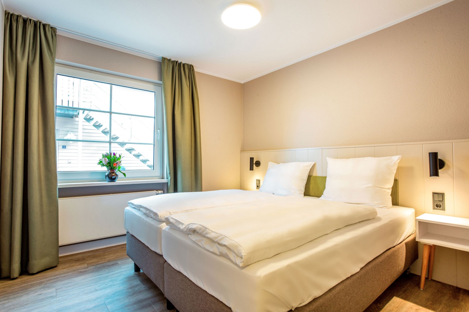 Helles Schlafzimmer mit Doppelbett in der Ferienwohnung am Fleesensee