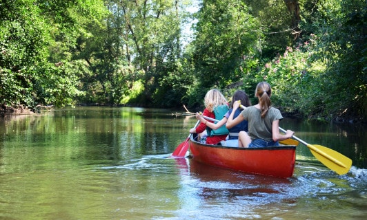 Frauen fahren Kanu auf einem Fluss