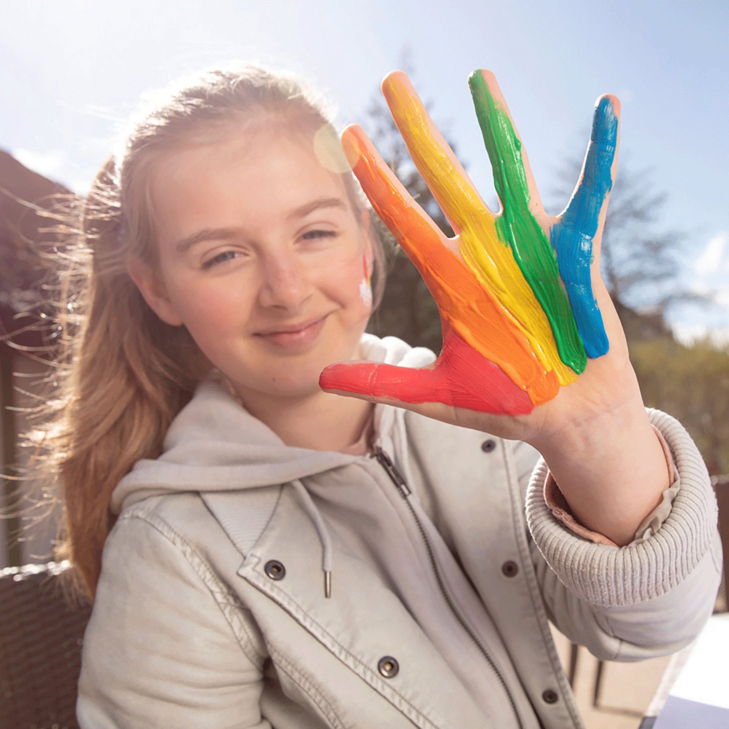 Kind mit Fingerfarben an der Hand